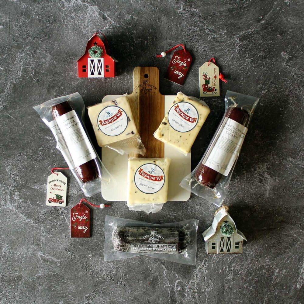 Charcuterie holiday gift box with assorted Christensen Ranch beef summer sausages and assorted Rocking W Cheeses and an engraved acacia and marble charcuterie board